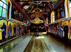 prestone ikone i rezbareni ikonostas, unutrašnjost crkve u Čajetini osvijetljena svjetlošću kandila i lustera u Čajetini