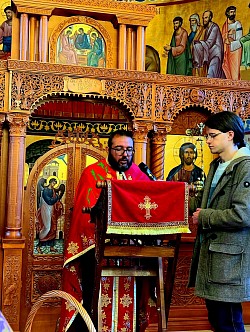 Detaljan prikaz jeromonaha iz manastira Dubrava i manastira Uvac dok uznose jevanđeljske molitve za ozdravljenje duše i tela tokom službe jeleosvećenja u crkvi u Čajetini. Fokus je na dostojanstvu monaškog čina i njihovom molitvenom posredovanju dok drže upaljene sveće pored otvorenog Jevanđelja. Prisustvo monaštva zajedno sa parohijskim sveštenstvom iz Čajetine i Zlatibora naglašava duhovnu snagu kojom se brani zdravlje vernog naroda. Svaka reč koju izgovaraju monasi tokom čitanja Jevanđelja odjekuje hramom Svetog arhangela Gavrila, donoseći mir i nadu prisutnim vernicima, monahinjama iz Dubrave i meštanima koji su došli na ovu veliku molitvu na Velikoj sredi